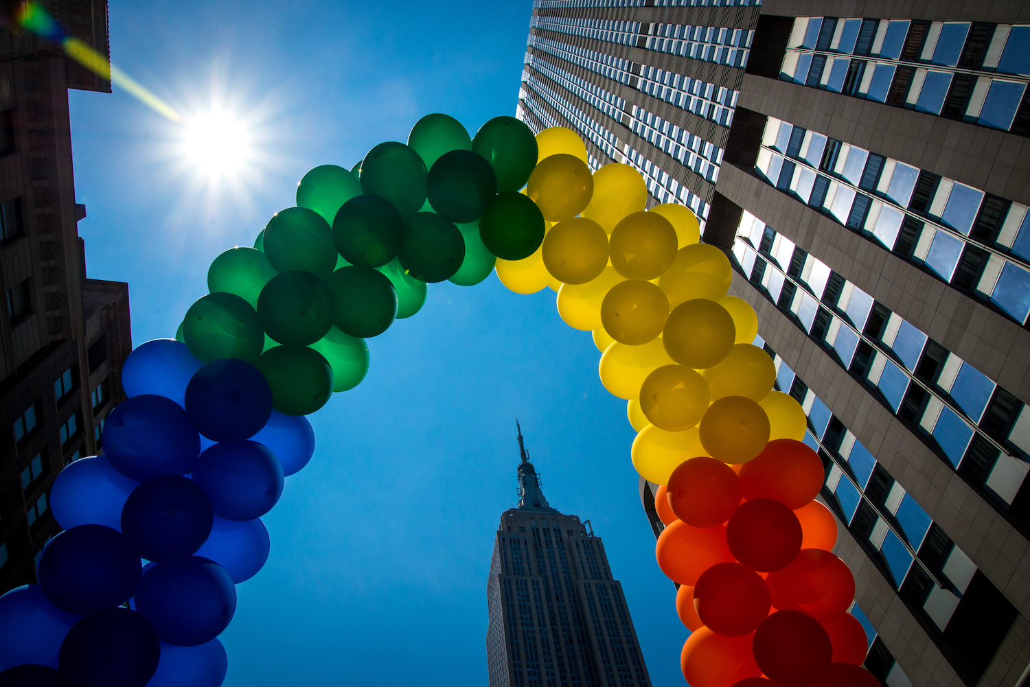 Image of a rainbow made out of balloons with an upward view of the Empire State Building 